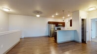 Located at 16511 East Sprague Avenue in Spokane Valley, WA, Unit F4 is a single-floor residence designed with functionality and modern style in mind. The open-concept layout connects the living area to the kitchen, creating a spacious, cohesive environment. Wood-style flooring runs throughout the main living spaces, complementing the neutral color palette and clean lines of the interior.

The kitchen is well-equipped with rich dark cabinetry, light stone-toned countertops, a full suite of stainless steel appliances including a refrigerator, range, and microwave, and a double-basin sink. A peninsula with pendant lighting separates the kitchen from the living area, offering additional counter space and a natural gathering point. Recessed lighting and decorative fixtures provide ample illumination throughout.

The living area is generously sized with windows that bring in natural light and views of the surrounding neighborhood. The bedroom features plush carpeting, a window with exterior views, and baseboard heating. The bathroom is outfitted with a full tub/shower combination, dark vanity cabinetry, and stone-look countertops. A dedicated in-unit laundry area with a washer and overhead shelving adds everyday convenience to this practical and comfortable Spokane Valley residence.