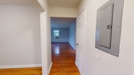 Located at 88 Woodland Rd in Short Hills, NJ, this single-floor unit offers a thoughtfully laid-out living space with a clean, neutral aesthetic throughout. Polished hardwood floors extend across the living areas and bedrooms, reflecting natural light and lending warmth to every room.

The kitchen stands out as a notably updated space, featuring white shaker cabinetry, granite countertops, a decorative mosaic tile backsplash, and a full suite of stainless steel appliances including a gas range, built-in microwave, and dishwasher. Wood-look flooring completes the kitchen's contemporary feel.

The living area is generously proportioned, with multiple windows allowing natural light to fill the space and offering views of the surrounding greenery. A window-unit air conditioner provides cooling convenience. Baseboard heating runs consistently throughout the unit, ensuring comfort year-round.

The bedrooms are well-sized, each featuring hardwood floors, neutral walls, and windows that bring in natural light. Several rooms include closet storage. The bathroom features a clean, white-tiled tub and shower combination with brushed nickel fixtures. A centrally located hallway connects the rooms efficiently, with a utility panel accessible nearby.