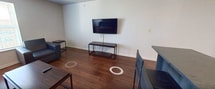 Located at 3839 Hunsaker Dr in East Lansing, MI, this efficiently designed 490-square-foot, one-bedroom, one-bathroom apartment offers a functional single-floor layout. The living room features warm hardwood-style flooring, neutral walls, and a glazed exterior door that allows natural light to fill the space, creating an open and welcoming ambiance. The kitchen is well-appointed with stainless steel appliances, including a refrigerator, range, microwave, and dishwasher, complemented by dark countertops and medium-toned cabinetry arranged in an L-shaped configuration. The 160-square-foot bedroom is carpeted for comfort and includes dual sliding-door closets offering ample storage. The bathroom features white cabinetry, a dark countertop vanity, a large wall mirror, and dark hardwood-style flooring, providing a clean and practical finish. Throughout the apartment, the design emphasizes efficient use of space with a straightforward, neutral color palette. This apartment is well-suited for a single occupant or student seeking a functional and self-contained living space in the East Lansing area.