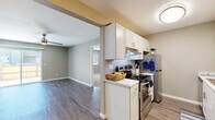 This single-floor residence in Suisun City, California, offers a thoughtfully designed layout that balances functionality and comfort. The open-concept living area is finished with durable wood-style flooring and neutral gray tones, creating a bright and welcoming atmosphere. A ceiling fan with a light fixture enhances air circulation, while a sliding glass door connects the living space to an outdoor patio, allowing for ample natural light.

The galley-style kitchen is efficiently organized with crisp white cabinetry, marble-look countertops, and stainless steel appliances, including a range and refrigerator. A dedicated sink area with additional cabinet storage lines the opposite wall, maximizing workspace and storage capacity.

The bedrooms feature plush carpeting, neutral wall tones, and windows that invite natural light. The primary bedroom connects conveniently to a hallway with closet space and in-unit laundry hookups, adding everyday practicality.

The bathroom is well-appointed with a marble-look vanity countertop, white cabinetry, a tub-shower combination, and wood-style flooring that ties seamlessly into the rest of the unit. Clean, consistent finishes throughout the home create a cohesive and move-in-ready feel, making this a practical and comfortable space in the San Francisco Bay Area.