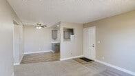 Located at 1180 Matmor Rd in Woodland, CA, this single-story, 2-bedroom, 2-bathroom home offers a thoughtfully organized floor plan with a clean, neutral aesthetic throughout. The entry opens into a carpeted living area with a textured ceiling and ceiling fan, flowing naturally toward the combined dining and kitchen space. The kitchen is well-appointed with gray cabinetry, light countertops, a stainless steel sink, and white appliances including a range and refrigerator. Light wood-look vinyl flooring, recessed lighting, and a ceiling fan give the kitchen a bright and functional feel. Both bedrooms are carpeted and finished in warm neutral tones. The primary bedroom features a sliding glass door leading to an outdoor balcony with views of surrounding greenery, while the second bedroom includes a window with natural light and access to a walk-in closet with multi-rail shelving. Each bathroom is clean and practical — one features a full tub/shower combo with chrome fixtures and a vanity, while the other includes wood-look flooring and a grab bar for added accessibility. A hallway connects the bedrooms and bathrooms, and two closets provide ample storage. Textured ceilings are consistent throughout, and white trim and baseboards lend a crisp, finished look to every room.