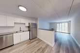 Located at 1055 Southern Artery in Quincy, MA, this two-bedroom, one-bathroom unit offers a well-organized single-floor layout designed for comfortable everyday living. Light wood-style flooring runs throughout the main living areas, lending a clean, modern feel to the space. The kitchen is thoughtfully appointed with white shaker cabinets, a white subway tile backsplash, dark countertops, and a full suite of stainless steel appliances including a refrigerator, dishwasher, and range. A half-wall peninsula separates the kitchen from the living area, creating an open and connected feel. The living room is bright and airy, anchored by a large sliding glass door that opens to a private balcony with lush, tree-lined views. Both bedrooms feature soft carpeting and ample closet space, with the primary bedroom offering a generous double-door closet. A hallway connects the bedrooms to the full bathroom, which is finished with a soaking tub and floor-to-ceiling marble-style tile surround. Additional storage is provided by multiple closets accessible from the hallway. The unit's neutral color palette and updated finishes create a fresh, move-in-ready atmosphere throughout.