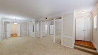 Located on Fountain View Drive in Houston's Galleria area, this single-floor, 2-bedroom, 2-bathroom residence offers a well-organized layout with distinct architectural character throughout. The living area is defined by white decorative columns, wainscoting-style wall paneling, and mirrored wall accents that add depth and visual interest to the open carpeted space. Crown molding runs throughout the main living and bedroom areas, contributing a refined, cohesive aesthetic. Natural light enters through multiple windows fitted with horizontal blinds.

The galley-style kitchen features white cabinetry, speckled countertops, hardwood flooring, and white appliances including a range and refrigerator. A stacked washer and dryer unit is conveniently integrated within the kitchen area. The spacious primary bedroom is notably generous in scale, offering carpet flooring, crown molding, a pendant light fixture, and built-in shelving. The second bedroom includes a mirrored sliding-door closet and a ceiling fan with lighting. Four closets total provide ample storage throughout the unit. Both bathrooms are finished in a clean, neutral palette, with one featuring a full tub-shower combination with white tile surround and the other offering a wide vanity with a large mirror and white cabinetry.
