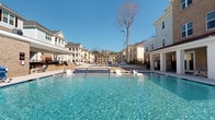 Located in the desirable community of Mount Pleasant, South Carolina, this outdoor amenity space at Legacy Eagle Drive showcases a stunning resort-style pool that serves as the centerpiece of the community. The generously sized pool features crystal-clear blue water, gradual entry points, and a connected spa or wading area, all finished with classic tile detailing along the edges.

Surrounding the pool, a spacious sundeck provides ample room for lounge chairs and relaxation under the abundant South Carolina sunshine. The area is framed by elegant, multi-story residential buildings with classic Southern architectural character — featuring white columns, covered balconies, and brick accents that lend a refined, cohesive aesthetic to the entire community.

Lush landscaping and mature trees add natural beauty and a sense of privacy to the outdoor space. The open layout allows for generous airflow and unobstructed sightlines across the water, enhancing the sense of openness and resort-like atmosphere. Whether used for leisurely swimming, sunbathing, or simply enjoying the scenic surroundings, this community amenity space reflects the high standard of outdoor living that defines the Legacy Eagle Drive community in Mount Pleasant.