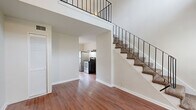 Located at 1606 King Street in Jacksonville, FL, this two-story, one-bedroom, one-bathroom home offers a thoughtfully arranged layout spread across two floors. The main level features warm hardwood-style flooring throughout the living area and kitchen, with an open staircase accented by sleek black metal railings that rises to the upper floor, creating a sense of vertical openness. The kitchen is well-appointed with white shaker-style cabinetry, granite countertops, a classic white subway tile backsplash, stainless steel appliances including a refrigerator and range, and a window that brings in natural light. Upstairs, the generously sized bedroom is finished with plush carpet and features a distinctive shiplap ceiling that adds architectural character. A walk-in closet provides ample storage, and the upper level also includes convenient access to the bathroom. The bathroom is cleanly designed with full subway tile walls in the shower, a mosaic penny-tile floor, and a pedestal sink, creating a crisp, classic aesthetic. A hallway loft area at the top of the stairs adds flexible open space. Overall, the home presents a clean, neutral palette with a blend of classic and modern touches throughout.