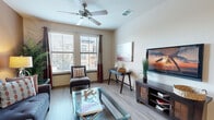 Located at 4652 Miramar Dr in St. Petersburg, Florida, this well-designed two-bedroom, two-bathroom residence offers a comfortable and functional single-floor layout. The open kitchen is a standout feature, showcasing granite countertops, warm wood cabinetry, black appliances including a full-size refrigerator and range, track lighting, and a peninsula breakfast bar with pendant lighting — seamlessly connecting to the living area. The living room is bright and inviting, with multiple large windows dressed in blinds and drape panels that allow generous natural light, complemented by wood-look flooring and a ceiling fan overhead. Both bedrooms are carpeted and generously sized, each featuring windows with natural light and dedicated closet space. The primary bedroom is notably spacious and connects conveniently to its own bathroom. The two bathrooms are finished with tile flooring, warm wood vanity cabinetry, stone-topped counters, and large mirrors. One bathroom includes a glass-enclosed shower, while the other features a tub-shower combination. A hallway connects the rooms, and the overall layout provides a logical and efficient flow throughout the residence. The warm, neutral color palette and quality finishes throughout contribute to a cohesive and comfortable living environment.