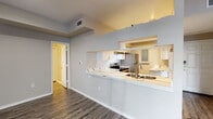 This single-floor residence is designed with a thoughtful, open layout that promotes a comfortable flow between living spaces. The kitchen serves as a central highlight, featuring white shaker-style cabinetry, quartz countertops with subtle veining, a classic subway tile backsplash, and a full suite of stainless steel appliances including a range, dishwasher, and refrigerator. A peninsula with an integrated sink extends into the living area, creating a practical pass-through that enhances the open-concept feel. Wood-look flooring runs throughout the main living and kitchen areas, providing a clean, modern aesthetic.

The living area is generously sized, bathed in natural light from multiple windows and a set of French doors that invite outdoor views. The bedrooms are carpeted for comfort, each equipped with a ceiling fan and windows fitted with blinds. One bedroom is notably spacious, while an additional bedroom offers a cozy, well-proportioned layout.

The bathrooms are finished with wood-look flooring, tiled tub-shower combinations accented with black tile detailing, and vanities topped with light-toned countertops. The primary bathroom features a dual-sink vanity and a closet, adding practicality to its clean, neutral design.