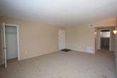 Located at 414 Turlington Rd in Newport News, Virginia, this single-story unit offers a straightforward and functional layout spread across several well-defined rooms. The living area is generously sized, finished with neutral-toned carpet and warm beige walls, and receives natural light through a window fitted with blinds, lending a bright and open feel to the space. The bedrooms continue the same carpeted flooring and neutral color palette, each offering a comfortable footprint. One bedroom features a walk-in closet, providing ample storage, while additional closet space is present throughout. The kitchen is equipped with white cabinetry, dark countertops, a stainless sink, and wood-look plank flooring that adds a warm contrast to the light walls. Black appliances, including a refrigerator and range, complete the kitchen setup. The bathroom features a full tub and shower combination with clean white tile surround, chrome fixtures, and dark wood-look flooring that ties in with the rest of the unit. Ceiling-mounted lighting and HVAC vents are consistently present throughout, ensuring comfort and practicality. The overall ambiance is clean, neutral, and move-in ready, making this Newport News unit a solid and functional living space.