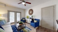 This thoughtfully designed 1-bedroom, 1-bathroom residence offers a complete and functional layout across a single floor. The living room serves as the heart of the home, featuring warm hardwood-style flooring, a ceiling fan, and French doors that invite natural light while providing outdoor access. The space is generous enough to comfortably accommodate a full seating arrangement. The kitchen is outfitted with rich dark cabinetry, granite-style countertops, black appliances including an electric range, and hardwood-style flooring — all arranged in an efficient galley configuration that maximizes storage and workspace. The bedroom is a comfortable retreat with plush carpeting, a ceiling fan, and a bright window. It connects to a dedicated closet, providing ample storage. The bathroom features dark vanity cabinetry with a granite-style countertop, a large mirror with overhead lighting, and clean tile flooring. A dedicated in-unit laundry room adds everyday convenience with overhead shelving. Throughout the residence, neutral wall tones and consistent finishes create a cohesive and inviting atmosphere, making this a practical and well-equipped living space.