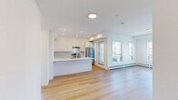 Located at 517 67 Ave SW in Calgary, this thoughtfully designed 3-bedroom, 1-bathroom unit offers a clean, modern aesthetic throughout. Light-toned hardwood flooring runs continuously across the single-level floor plan, complementing the crisp white walls and recessed lighting that keep the space feeling bright and airy.

The open-concept kitchen and living area serves as the heart of the unit. The kitchen is outfitted with sleek white cabinetry, white quartz countertops, a subway tile backsplash, stainless steel appliances including a refrigerator and electric range, and a central island with an undermount sink — ideal for both cooking and casual dining.

The living area opens directly onto a private balcony through glass-paneled doors, offering views of the surrounding Calgary skyline and neighborhood. A wall-mounted ductless air conditioning unit and baseboard heaters provide year-round climate control.

The three bedrooms are well-proportioned and feature light-filled windows with city views, and include dedicated closet space with built-in shelving. A conveniently located in-unit stacked washer and dryer adds everyday practicality.

The full bathroom is finished with wood-tone flooring, a bathtub with glass shower enclosure, a white vanity, and clean, neutral tiling throughout.