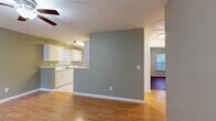 This 2-bedroom, 2-bathroom single-floor home in Rock Hill, SC offers a practical and comfortable layout designed for everyday living. The open-concept main area seamlessly connects the living room, dining area, and kitchen, creating a cohesive and functional space. The living room features warm hardwood-style flooring, a ceiling fan with light fixture, and large windows that invite natural light and provide outdoor views of the surrounding greenery. Muted sage green walls lend a calm, consistent tone throughout the main living areas.

The kitchen is equipped with white cabinetry, a double sink, white appliances including a range and dishwasher, light tile flooring, and a pass-through counter that connects to the living and dining areas. A pendant light fixture adds a finishing touch overhead.

The primary bedroom offers generous space, dark hardwood-style flooring, a ceiling fan, a window with outdoor views, and a well-sized closet with wire shelving. The second bedroom mirrors a similar layout with its own window and ceiling fan. Both bathrooms feature white vanities with under-cabinet storage, mirrors, and chrome fixtures. The utility room includes wire shelving and washer/dryer connections. Three closets throughout the home provide ample storage for all residents.