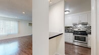 Located at 5345 N Sepulveda Blvd in Los Angeles, this single-floor unit offers a well-organized layout that makes efficient use of its space. The kitchen is a standout feature, showcasing white shaker cabinetry, dark granite countertops, a bold mosaic tile backsplash in shades of black, grey, and white, and a full suite of stainless steel appliances including a refrigerator, dishwasher, and gas range. Wood-look flooring runs throughout, lending warmth and cohesion across all areas. The open living area is bright and clean, with white walls, recessed lighting, a textured ceiling, and a large window fitted with vertical blinds that allow for natural light control. A wall-mounted air conditioning unit and ceiling fan provide year-round climate comfort. The walk-in closet offers dual hanging rods along three walls, providing generous storage for its footprint. The bathroom features a clean, all-white design with a combination tub and shower enclosed by sliding glass doors with brushed nickel hardware. The overall aesthetic is modern and functional, with a neutral palette and updated finishes throughout that create a cohesive, move-in ready environment.