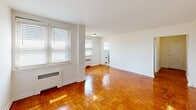 Located at 1300 N Harrison St in Wilmington, Delaware, this one-bedroom, one-bathroom unit offers a well-organized layout across a single floor. Polished parquet hardwood flooring flows throughout the main living areas and bedroom, lending a warm, classic character to the space.

The entrance hall leads into a combined living and dining room that serves as the heart of the unit. This open area is bathed in natural light from multiple windows fitted with blinds, and radiator heating units line the walls. The clean white walls and gleaming floors create a bright, airy ambiance.

The kitchen is efficiently arranged in a galley style, featuring white shaker-style cabinetry, gray countertops, a stainless steel sink with a brushed-nickel faucet, and a gas range. Light marble-style tile flooring and a window above the stove contribute to a clean, functional workspace.

The bedroom is a generously sized room with its own ceiling fan and light fixture, parquet flooring, and access to closet storage. Three closets throughout the unit provide ample storage options.

The bathroom is finished in crisp white tile wainscoting, with a pedestal sink, toilet, vanity mirror with overhead lighting, and a window that allows natural light in. Light wood-tone tile flooring completes the clean, bright aesthetic.