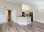 Located at 9873 Lawrence Rd in Boynton Beach, Florida, this single-floor residence offers a thoughtfully designed open-concept layout with a clean, contemporary aesthetic throughout. The heart of the home is the kitchen, which features white shaker-style cabinetry, a subway tile backsplash, dark countertops, and a full suite of stainless steel appliances including a refrigerator, range, and over-the-range microwave. A peninsula with an integrated sink extends into the living and dining area, creating a seamless flow ideal for entertaining. A stylish chandelier anchors the dining space, while wood-look plank flooring extends throughout the main living areas, adding warmth and durability. Sliding glass doors lead to an outdoor balcony, allowing natural light to fill the space. The bedrooms are carpeted for comfort and feature windows that bring in greenery views, along with generous closet storage — including a primary bedroom with dual closets. A dedicated walk-in style closet off one bathroom provides additional storage. The bathroom is well-appointed with white cabinetry, a dark countertop vanity, and a tub/shower combination. Neutral wall tones and consistent finishes create a cohesive, move-in-ready atmosphere throughout the entire home.