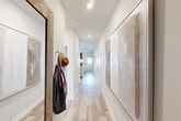 Located in Fort Oglethorpe, GA, this well-appointed 2-bedroom, 2-bathroom single-story home offers a thoughtfully designed layout with modern finishes throughout. Light wood-tone flooring flows through the interior, complemented by bright white walls and recessed lighting that create a clean, contemporary feel.

The entryway welcomes you with a long hallway adorned with framed artwork and a practical wall hook, setting a polished tone. The open-concept kitchen and living area serves as the heart of the home. The kitchen is outfitted with crisp white shaker cabinetry, subway tile backsplash, stone-look countertops, stainless steel appliances, and a peninsula with sink — ideal for both cooking and casual dining.

The primary bedroom is generously proportioned, featuring large windows that bring in ample natural light and an en suite bathroom with a wide granite-topped vanity and hardwood-style flooring. The second bedroom also enjoys natural light from a sizable window. A full second bathroom mirrors the same refined design as the primary bath.

Three closets offer excellent storage, while a dedicated laundry area adds everyday convenience. The attached garage provides secure parking and additional utility space with an automatic door opener and electrical panel access. This home combines efficient use of space with modern design in a single-level layout.