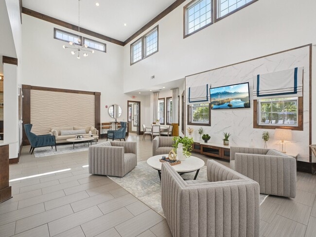 Bright and spacious resident clubhouse with modern lounge seating at Village at Broadstone Station in Apex, North Carolina - Village at Broadstone Station