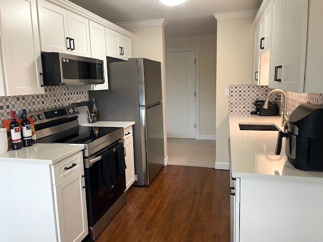 Newly remodeled kitchen has quartz countertops, stainless steel convection range, microwave, refrig - 5818 NE 70th St