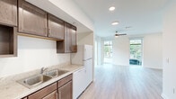 Located in New Orleans, LA 70113, this 1-bedroom, 1-bathroom unit offers a thoughtfully designed single-level layout that maximizes functionality and comfort. Light wood-style flooring flows consistently throughout the space, complementing the clean, neutral-toned walls and creating a bright, cohesive aesthetic.

The open-concept living area is a standout feature, bathed in natural light from oversized floor-to-ceiling windows and a glass door that frame views of the surrounding neighborhood. A ceiling fan adds comfort to the airy living space.

The kitchen is well-appointed with rich dark wood cabinetry, light countertops, a double-basin sink, and white appliances including a range, dishwasher, and refrigerator. Recessed lighting illuminates the workspace efficiently. A dedicated in-unit laundry closet with a washer adds everyday convenience.

The bedroom is generously proportioned, featuring a large sliding glass door that fills the room with natural light and provides outdoor access. A ceiling fan and a reach-in closet with shelving complete the room.

The full bathroom is cleanly finished, featuring a single-sink vanity with dark wood cabinetry, a white countertop, a large mirror with overhead lighting, and a tub/shower combination. The overall design of this New Orleans unit balances practicality with a clean, modern sensibility.