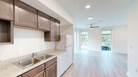 Located in New Orleans, LA 70113, this 1-bedroom, 1-bathroom unit offers a thoughtfully designed single-level layout that maximizes functionality and comfort. Light wood-style flooring flows consistently throughout the space, complementing the clean, neutral-toned walls and creating a bright, cohesive aesthetic.

The open-concept living area is a standout feature, bathed in natural light from oversized floor-to-ceiling windows and a glass door that frame views of the surrounding neighborhood. A ceiling fan adds comfort to the airy living space.

The kitchen is well-appointed with rich dark wood cabinetry, light countertops, a double-basin sink, and white appliances including a range, dishwasher, and refrigerator. Recessed lighting illuminates the workspace efficiently. A dedicated in-unit laundry closet with a washer adds everyday convenience.

The bedroom is generously proportioned, featuring a large sliding glass door that fills the room with natural light and provides outdoor access. A ceiling fan and a reach-in closet with shelving complete the room.

The full bathroom is cleanly finished, featuring a single-sink vanity with dark wood cabinetry, a white countertop, a large mirror with overhead lighting, and a tub/shower combination. The overall design of this New Orleans unit balances practicality with a clean, modern sensibility.