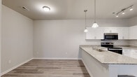 Located on Shannon Oaks Ct in Spartanburg, SC, this single-story, 3-bedroom, 2-bathroom home offers a well-designed layout with modern finishes throughout. Light-toned, wood-look luxury vinyl plank flooring runs consistently across all rooms, contributing to a clean, cohesive aesthetic.

The open-concept kitchen and living area forms the heart of the home. The kitchen features white shaker-style cabinetry, granite countertops, stainless steel appliances — including a refrigerator, electric range, and microwave — and a peninsula with pendant lighting that overlooks the living space. The living area benefits from natural light through double French doors that open to a balcony.

Three bedrooms each offer neutral wall tones, natural light from windows with blinds, and ample space. The generously sized primary bedroom provides a comfortable retreat. Both bathrooms are finished with granite-top vanities, white cabinetry, and undermount sinks paired with large mirrors, maintaining the home's consistent, contemporary style. The overall ambiance is bright, clean, and move-in ready.