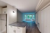 Located at 144 Larkin Way in South Burlington, Vermont, this one-bedroom, two-bathroom residence offers a thoughtfully designed single-level layout with a clean, modern aesthetic. Rich hardwood-style flooring runs throughout the main living spaces, lending warmth and visual continuity.

The open-concept living and dining area is a standout feature, anchored by a prominent bay window that frames lush, tree-lined views and floods the room with natural light. The kitchen is well-equipped with crisp white shaker-style cabinetry, dark countertops, stainless steel appliances, and a peninsula that provides both additional workspace and a natural division between the kitchen and living areas. Track lighting above the cabinetry ensures practical illumination.

The bedroom is a comfortable, well-proportioned space with a large window offering serene views of the surrounding greenery. Two closets provide ample storage throughout the unit. A hallway connects the private quarters to both bathrooms, one of which features a full tub-shower combination, tile flooring, and a vanity with a white countertop. Neutral wall tones throughout the residence create a calm, inviting atmosphere well-suited to a variety of interior styles.