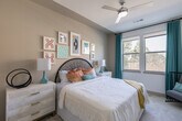 Located at 9330 Main St in Houston, TX, this single-floor residence offers a thoughtfully designed layout with contemporary finishes and a bright, welcoming ambiance throughout. The kitchen serves as a central highlight, featuring sleek gray flat-front cabinetry extending to the ceiling, stainless steel appliances including a refrigerator, range, and microwave, white subway tile backsplash, and a generous granite-topped island that doubles as a breakfast bar. Light wood-style flooring flows through the kitchen and main living areas, enhancing the clean, modern aesthetic. Multiple bedrooms provide comfortable retreats, each carpeted and filled with natural light from large windows with outdoor views of surrounding greenery. The primary bedroom includes a ceiling fan and ample space, while additional bedrooms offer distinct character and versatility. The bathrooms are well-proportioned, showcasing granite countertops, gray cabinetry with ample storage, wide vanity mirrors, wood-look flooring, and a shower-tub combination. One bathroom features a walk-through layout connecting to a spacious closet with built-in shelving. Throughout the residence, recessed lighting and a neutral color palette create a clean, cohesive atmosphere well-suited for modern living.