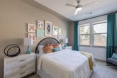 Located at 9330 Main St in Houston, TX, this single-floor residence offers a thoughtfully designed layout with contemporary finishes and a bright, welcoming ambiance throughout. The kitchen serves as a central highlight, featuring sleek gray flat-front cabinetry extending to the ceiling, stainless steel appliances including a refrigerator, range, and microwave, white subway tile backsplash, and a generous granite-topped island that doubles as a breakfast bar. Light wood-style flooring flows through the kitchen and main living areas, enhancing the clean, modern aesthetic. Multiple bedrooms provide comfortable retreats, each carpeted and filled with natural light from large windows with outdoor views of surrounding greenery. The primary bedroom includes a ceiling fan and ample space, while additional bedrooms offer distinct character and versatility. The bathrooms are well-proportioned, showcasing granite countertops, gray cabinetry with ample storage, wide vanity mirrors, wood-look flooring, and a shower-tub combination. One bathroom features a walk-through layout connecting to a spacious closet with built-in shelving. Throughout the residence, recessed lighting and a neutral color palette create a clean, cohesive atmosphere well-suited for modern living.