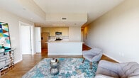 Located at 850 Pacific St in Stamford, Connecticut, this thoughtfully designed one-bedroom, one-bathroom residence offers a modern open-concept layout with warm wood-style flooring throughout. The living area is bright and welcoming, anchored by large sliding glass doors that lead to a private balcony, framing sweeping elevated views of the Stamford cityscape and beyond.

The kitchen is outfitted with light wood cabinetry, a clean white quartz-style island and countertops, and stainless steel appliances including a gas range, built-in microwave, and a full-size refrigerator — ideal for everyday cooking and entertaining.

A wide entry hallway leads to the spacious bedroom, which features floor-to-ceiling windows that fill the room with natural light and offer striking elevated views. Two closets provide generous storage throughout the unit. The bathroom includes a full tub-shower combination with white tile surround and chrome fixtures.

Practical conveniences include an in-unit laundry area. Neutral tones and clean architectural lines carry throughout the space, creating a calm and contemporary ambiance well-suited for modern living in downtown Stamford.