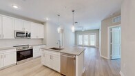 Located at 4434 Cobalt Brook Boulevard in Lutz, Florida, this well-appointed single-story home offers 2 bedrooms and 2 bathrooms with a clean, modern aesthetic throughout. Light wood-look flooring flows seamlessly across the entire floor plan, creating a bright and cohesive feel.

The open-concept kitchen and living area serves as the heart of the home. The kitchen features white shaker cabinetry, stone countertops, a center island with a built-in sink and dishwasher, stainless steel appliances including a side-by-side refrigerator and range, and elegant pendant lighting overhead. The living area extends naturally from the kitchen, bathed in natural light from glass French doors that open to the outdoors, and is outfitted with a ceiling fan.

Both bedrooms are generously sized, each with ceiling fans, neutral-toned walls, and natural light from windows with blinds. The spacious primary bedroom includes walk-in closet access with wire shelving systems. A total of four closets throughout the home—each equipped with wire shelving—provide excellent storage.

The bathrooms are finished in crisp white with shaker-style vanities, stone countertops, backlit mirrors, and tub-shower combinations. A dedicated laundry area and connecting hallway complete this well-organized, move-in-ready home.
