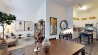 Located at 28 Southfield Ave in Stamford, Connecticut, this well-appointed one-bedroom, one-bathroom residence offers a sophisticated blend of modern design and comfortable living across a single floor. The open-concept living and dining area is distinguished by soaring ceilings that amplify the sense of space, complemented by wide-plank hardwood-style flooring and crisp white walls that create a bright, airy atmosphere. Large windows invite abundant natural light and provide views of the surrounding neighborhood. The kitchen is fully equipped with stainless steel appliances—including a gas range, microwave, and refrigerator—alongside white shaker cabinetry, granite countertops, and durable wood-style flooring, making it as functional as it is attractive. A central island offers additional prep space and casual seating. The bedroom is a serene retreat, featuring generous natural light from a wide window and wall-mounted media accommodations. The bathroom is finished with a clean, contemporary aesthetic, showcasing a white vanity with undermount sink, quartz countertop, and a well-lit mirror. Throughout the residence, thoughtful architectural details—including elevated ceiling heights in the main living areas—contribute to an overall sense of openness and refined urban living.