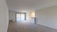 Located at 12215 Little Patuxent Pkwy in Columbia, MD, this single-floor, 2-bedroom, 1-bathroom residence offers a well-organized and functional layout. The spacious living room features neutral-toned carpet and large sliding glass doors with vertical blinds, allowing generous natural light and outdoor views. A pass-through counter connects the living area to the kitchen, creating an open, communicative flow between spaces. The kitchen is equipped with cabinetry and appliances, keeping utility within a compact footprint. Both bedrooms are carpeted and finished with clean white walls. The primary bedroom is generously sized, featuring large windows that bring in ample natural light and views of the surrounding exterior. The second bedroom also benefits from natural light and convenient access to the hallway. The full bathroom includes wood-look flooring, a tiled tub-surround shower with a curtain rod, and a vanity with white cabinetry. A dedicated laundry area and a closet add practical storage and convenience. Throughout the residence, a consistent neutral color palette, white panel doors, and carpeted flooring lend a cohesive and clean aesthetic, making it a comfortable and move-in ready home.