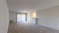 Located at 12215 Little Patuxent Pkwy in Columbia, MD, this single-floor, 2-bedroom, 1-bathroom residence offers a well-organized and functional layout. The spacious living room features neutral-toned carpet and large sliding glass doors with vertical blinds, allowing generous natural light and outdoor views. A pass-through counter connects the living area to the kitchen, creating an open, communicative flow between spaces. The kitchen is equipped with cabinetry and appliances, keeping utility within a compact footprint. Both bedrooms are carpeted and finished with clean white walls. The primary bedroom is generously sized, featuring large windows that bring in ample natural light and views of the surrounding exterior. The second bedroom also benefits from natural light and convenient access to the hallway. The full bathroom includes wood-look flooring, a tiled tub-surround shower with a curtain rod, and a vanity with white cabinetry. A dedicated laundry area and a closet add practical storage and convenience. Throughout the residence, a consistent neutral color palette, white panel doors, and carpeted flooring lend a cohesive and clean aesthetic, making it a comfortable and move-in ready home.