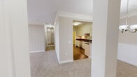 Located at 2111 Greystone Vista Way in Knoxville, TN, this well-appointed single-story home offers three bedrooms, two bathrooms, and a thoughtfully designed layout. The interior is finished with neutral tones, crown molding, and plush carpet throughout the main living and bedroom areas. The living room is bright and open, featuring a ceiling fan with light fixture and French doors that invite natural light and outdoor views. The adjacent dining area is accented by an elegant multi-bulb chandelier and classic wainscoting panels. The kitchen is equipped with stainless steel appliances — including a refrigerator, range, and built-in microwave — complemented by white shaker-style cabinetry extending to the ceiling, dark granite countertops, and durable hardwood-style flooring. The spacious primary bedroom includes a ceiling fan, multiple windows, and access to a walk-in closet outfitted with wire shelving. The bathrooms feature tile flooring, granite-topped vanities with undermount sinks, and a tub/shower combination. Additional highlights include a utility room, a central hallway connecting all rooms, and ample closet storage throughout the home.