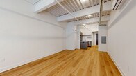 Located at 101 N Queen St in the heart of downtown Lancaster, PA, this thoughtfully designed unit blends modern finishes with industrial character. The open-concept living and kitchen area is anchored by warm hardwood flooring that runs throughout, while exposed steel beams, corrugated metal ceiling panels, and visible ductwork lend an urban loft aesthetic. A wall-mounted mini-split system ensures year-round comfort. Natural light filters in through a street-facing window, brightening the clean white walls of the living space.

The kitchen is well-appointed with dark-toned shaker cabinetry, white quartz countertops, stainless steel appliances including a built-in microwave, refrigerator, and dishwasher, along with open metal shelving for additional storage. A peninsula with a stainless steel sink adds both function and a natural divide between the kitchen and living areas.

The hallway connects to a dedicated in-unit laundry closet with a stacked washer and dryer, as well as a walk-in closet. The full bathroom features a dark wood vanity with quartz countertop, neutral tile flooring, and a clean, minimalist design. A utility panel is conveniently located near the entry.