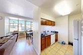 Located on College Avenue in the heart of Ithaca, NY, this well-appointed 4-bedroom, 2-bathroom unit offers a thoughtfully designed single-floor layout. The open-concept living and dining area is bright and welcoming, featuring light hardwood floors and large windows that frame views of the surrounding urban streetscape, filling the space with natural light. The living room provides ample room for seating and entertainment, with a wall-mounted television and direct sightlines to the dining area.

The kitchen is efficiently designed with warm wood cabinetry, dark granite countertops, a breakfast bar with seating for three, and standard appliances including a dishwasher, stove, and refrigerator. A pass-through window connects the kitchen to the living area, enhancing the open feel.

Each of the four bedrooms features carpeted flooring, a dedicated closet, and windows that let in plentiful daylight. The primary bedroom offers a comfortable footprint well-suited for a full-sized bed and workspace. The two bathrooms are finished with tile flooring, granite-topped vanities with wood cabinetry, and a tub-shower combination enclosed by sliding glass doors. A hallway connects the private and shared areas of the unit seamlessly.