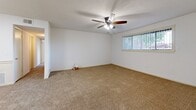 Located at 2330 N Oliver St in Wichita, Kansas, this single-floor unit offers two bedrooms and three bathrooms within a well-organized, functional layout. The open kitchen features white cabinetry, dark granite-style countertops, a peninsula with additional counter space, and black appliances including a refrigerator and range. The kitchen flows into a carpeted living area, creating a connected and practical common space. A ceiling fan with lighting is installed in the living area, which also benefits from natural light through a window with vertical blinds. Both bedrooms are carpeted and finished with clean white walls and textured ceilings. The primary bedroom is generously sized and includes a dedicated closet, while the second bedroom offers its own window with natural light. The three bathrooms feature wood-look flooring, white cabinetry, and speckled countertops with single-basin sinks and mirrors. The bathrooms are clean and simply appointed, providing a functional and tidy aesthetic throughout. The overall design of the unit is straightforward and neutral, with consistent finishes across rooms including beige carpet, white walls, and warm-toned surfaces that lend a cohesive, move-in-ready feel to the entire space.