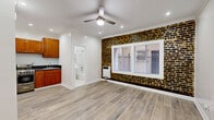 Located at 738 S New Hampshire Ave in the heart of Los Angeles, this efficiently designed studio offers a thoughtful layout across a single floor. The combined kitchen and living area serves as the heart of the space, highlighted by a striking exposed brick accent wall that adds warmth and character. Light wood-style flooring runs throughout, complemented by crisp white crown molding and recessed lighting. A ceiling fan anchors the living area, while a large window allows natural light to fill the room. The kitchen is equipped with warm-toned wood cabinetry, stainless steel appliances including a gas range and refrigerator, and dark countertops, offering a functional cooking area. A walk-in closet provides dedicated storage, an uncommon feature that adds practical value to the space. The bathroom showcases elegant marble-style tile surrounding a full soaking tub, a clean white toilet, and a window for natural ventilation. A wall-mounted heater in the main room ensures year-round comfort. The overall ambiance balances urban character with clean, modern updates, making this Los Angeles studio a well-appointed and functional living space.