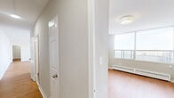 Located at 120 Shelborne Ave in Toronto's vibrant Glencairn neighbourhood, this well-appointed 3-bedroom, 2-bathroom unit offers a generous and functional layout across a single floor. Warm hardwood-style flooring flows throughout the living spaces, complementing the clean white walls and creating a bright, welcoming ambiance.

The open living room is notably spacious, filled with natural light through large windows that overlook the city skyline and surrounding greenery. A baseboard heating system ensures year-round comfort. The kitchen is thoughtfully designed with white cabinetry, marble-look countertops, a stainless steel electric range, and ample storage — a practical and attractive space for everyday living.

Three well-proportioned bedrooms provide comfortable personal retreats, with the primary bedroom offering generous space. Both bathrooms are finished with neutral tile, marble-look vanity countertops, white cabinetry, and mirrored medicine cabinets, with one featuring a full soaking tub.

A standout feature is the private balcony, which offers sweeping elevated views of Toronto's treetops and city buildings under open skies — ideal for relaxing outdoors. The unit is completed by a functional hallway entry that connects all areas of the home seamlessly.