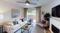 Located at 102 Stonemill Dr in Lynchburg, Virginia, this single-floor residence offers a thoughtfully designed layout that balances comfort and functionality. The living room serves as the heart of the home, featuring a ceiling fan, hardwood-style flooring, and large sliding glass doors that flood the space with natural light and open onto a private patio overlooking lush greenery.

The adjacent dining area is elegantly appointed with hardwood-style flooring, wainscoting, and a statement drum pendant light fixture. A convenient in-unit laundry closet is situated just off the dining space.

The galley-style kitchen is equipped with light wood cabinetry, a full suite of white appliances including a range, microwave, refrigerator, and dishwasher, along with a generous walk-in pantry for additional storage.

Both bedrooms feature plush carpeting and natural light from windows with blinds. The primary bedroom includes a ceiling fan and access to a spacious walk-in closet with extensive wire shelving. Each bedroom is served by its own full bathroom, both featuring wood-style flooring, a vanity with light cabinetry, and a tub-shower combination. The overall ambiance is warm, clean, and inviting throughout.