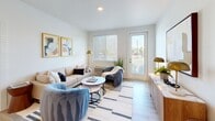 Located at 917 SW 31st St in Battle Ground, Washington, this 2-bedroom, 2-bathroom apartment offers a well-designed single-floor layout with a clean, modern aesthetic throughout. Light wood-style flooring runs continuously through the main living areas, creating a cohesive and airy feel.

The open-concept kitchen and living area serves as the heart of the home. The kitchen features white cabinetry, stone-topped counters, stainless steel appliances including a refrigerator, microwave, and range, and a large center island with seating for four — ideal for casual dining or entertaining. Recessed lighting illuminates the space efficiently.

The living room benefits from generous natural light through large windows with blinds and includes direct access to an outdoor area via a glass-paneled door, extending the sense of space.

The primary bedroom is a well-proportioned retreat with a ceiling fan, a large window framing outdoor greenery, and a dedicated closet. The second bedroom also features a window with natural light and ample room for a workspace. Both rooms maintain the same light, neutral palette found throughout the unit.

Each of the two bathrooms is finished with white walls, light wood flooring, a vanity with stone countertops, and modern fixtures, offering a clean and functional design. Together, these spaces deliver a practical and contemporary living environment.