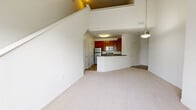 Located at 386 Attenborough Dr in Nottingham, MD, this two-bedroom, two-bathroom home spans two floors with a thoughtfully designed layout. The main level makes a strong impression with soaring vaulted ceilings in the living and dining area, filling the space with an airy, open feel. Large windows allow abundant natural light to pour in, complementing the plush neutral carpeting throughout. A stylish pendant light anchors the open-concept living area, which flows seamlessly into the kitchen. The kitchen is well-appointed with rich cherry wood cabinetry, dark granite-style countertops, stainless steel appliances including a gas range, microwave, refrigerator, and dishwasher, and wood-look flooring. A breakfast bar peninsula connects the kitchen to the main living space. A pantry and in-unit laundry add everyday convenience. Both bedrooms are generously sized with soft carpeting and double closets. The primary bedroom includes an en-suite bathroom. Both bathrooms feature tub-shower combinations, wood-look tile flooring, and clean white finishes. A loft on the upper level provides flexible bonus space, accessible via one of two staircases. Multiple closets throughout the home offer ample storage.
