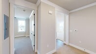 Located at 539 Town Madison Blvd in Madison, Alabama, this well-appointed two-bedroom, two-bathroom residence offers a thoughtfully designed single-floor layout. The open-concept kitchen and living area serves as the heart of the home, featuring white shaker cabinetry, a large central island with a light quartz countertop, stainless steel appliances, and elegant pendant lighting suspended above. Warm hardwood-style flooring anchors the kitchen and transitions seamlessly into the carpeted living area.

The primary bedroom is generously sized and includes direct access to a private en-suite bathroom outfitted with a dual-sink vanity, white cabinetry with matte black hardware, large-format tile flooring, and a glass-enclosed shower. A well-organized walk-in closet with built-in shelving and double hanging rods provides ample storage. The second bedroom features plush carpet, a ceiling fan, crown molding, and a bright window.

Throughout the home, neutral warm-gray tones, crisp white trim, and crown molding create a clean, cohesive aesthetic. A central hallway connects the bedrooms and bathrooms efficiently. The primary living area benefits from a glass French door that invites natural light and provides outdoor access, completing this move-in-ready residence.