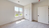 Located at 75 Willows Ct in Boston's vibrant 02125 zip code, this modern 2-bedroom, 1-bathroom home offers a thoughtfully designed single-floor layout. The interior is finished in a clean, neutral palette of soft whites and warm beige tones, creating a bright and cohesive aesthetic throughout.

Both bedrooms feature plush carpeting and large windows that invite generous natural light, with views of the surrounding neighborhood. The primary bedroom includes a double-door closet with matte black hardware, recessed lighting, and ample space for furnishings. The secondary bedroom is equally well-lit, offering a comfortable and versatile space suitable for a variety of uses.

The bathroom is finished with large-format tile flooring in a warm stone tone and features floor-to-ceiling white tile surrounding a soaking tub and shower combo. A wood-toned vanity and matte black fixtures add a contemporary contrast to the crisp, clean surroundings.

Throughout the home, consistent design details — including recessed lighting, clean white trim, modern interior doors with matte black hardware, and HVAC vents — reflect quality new construction finishes. A hallway connects the rooms efficiently, contributing to a practical and functional floor plan. This home presents a modern, move-in-ready living environment in the heart of Boston.