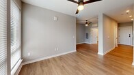 Located at 1711 Commonwealth Ave in Charlotte's vibrant Plaza Midwood neighborhood, this one-bedroom, one-bathroom unit offers a thoughtfully designed layout across a single floor. Light-toned luxury vinyl plank flooring flows throughout the space, complemented by neutral gray walls and clean white trim that create a cohesive, modern aesthetic.

The kitchen is a true standout, featuring bold navy lower cabinets paired with white upper cabinetry and open, live-edge wood shelving. A white subway tile backsplash, quartz countertops, a matte black undermount sink, and a full suite of stainless steel appliances — including a dishwasher, electric range, microwave, and refrigerator — complete the stylish and functional space.

The open living area is bright and airy, served by a ceiling fan and flows naturally toward the bedroom. The bedroom offers a comfortable footprint with a triple-panel window that fills the room with natural light and outward views of the surrounding neighborhood. A ceiling fan adds comfort year-round.

The walk-in closet is outfitted with multi-tiered wire shelving systems on all sides, maximizing storage capacity. The bathroom features a white vanity with quartz counters, a tall storage cabinet, matte black fixtures, and a tub-shower combination. In-unit laundry hookups round out this well-appointed home.