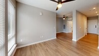 Located at 1711 Commonwealth Ave in Charlotte's vibrant Plaza Midwood neighborhood, this one-bedroom, one-bathroom unit offers a thoughtfully designed layout across a single floor. Light-toned luxury vinyl plank flooring flows throughout the space, complemented by neutral gray walls and clean white trim that create a cohesive, modern aesthetic.

The kitchen is a true standout, featuring bold navy lower cabinets paired with white upper cabinetry and open, live-edge wood shelving. A white subway tile backsplash, quartz countertops, a matte black undermount sink, and a full suite of stainless steel appliances — including a dishwasher, electric range, microwave, and refrigerator — complete the stylish and functional space.

The open living area is bright and airy, served by a ceiling fan and flows naturally toward the bedroom. The bedroom offers a comfortable footprint with a triple-panel window that fills the room with natural light and outward views of the surrounding neighborhood. A ceiling fan adds comfort year-round.

The walk-in closet is outfitted with multi-tiered wire shelving systems on all sides, maximizing storage capacity. The bathroom features a white vanity with quartz counters, a tall storage cabinet, matte black fixtures, and a tub-shower combination. In-unit laundry hookups round out this well-appointed home.