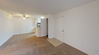 This 2-bedroom, 2-bathroom downstairs unit is thoughtfully designed to maximize comfort and functionality across a single floor. The open-concept living area features plush carpeting, a ceiling fan, and a cozy fireplace, with a sliding glass door that floods the space with natural light and provides direct access to an outdoor patio area. The galley-style kitchen is efficiently arranged with light wood cabinetry, a tile floor, a stainless steel refrigerator, an electric range, a microwave, and a sink with ample counter space — all accessible from the main living area. Both bedrooms are carpeted and generously sized, offering a quiet retreat. One bedroom includes a sliding-door closet with a hanging rod for convenient storage. The two bathrooms are finished with light wood vanities, white countertops, and tile flooring. The primary bathroom features a shower-tub combo with a sliding glass enclosure, while the second bathroom offers a similarly appointed shower-tub combination with a small window for natural light. The unit's neutral color palette and clean lines throughout create a bright, welcoming atmosphere well-suited for comfortable everyday living.