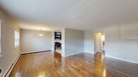 This well-appointed two-bedroom, one-bathroom residence at 40 Gill Ln in Iselin, NJ offers a functional and comfortable single-floor layout. Rich hardwood floors flow consistently throughout the home, lending warmth and cohesion to every room.

The open living area is bright and spacious, benefiting from multiple windows with blinds that allow natural light to fill the space. A wall-unit air conditioner and baseboard heating provide year-round climate control. The living area connects seamlessly to the galley-style kitchen, which features dark espresso cabinetry, white quartz countertops, a subway tile backsplash, stainless steel appliances including a gas range, microwave, and refrigerator, and a ceiling-mounted light fixture.

Both bedrooms are well-sized, with the primary bedroom offering a comfortable footprint. Each bedroom includes a closet with built-in hanging rods and is finished with the same hardwood flooring and neutral wall tones found throughout the home. A hallway connects the bedrooms to the rest of the unit.

The bathroom is cleanly updated, showcasing a dark vanity with a white countertop, an undermount sink, a modern brushed-nickel faucet, and an oval mirror. The overall aesthetic throughout is neutral and move-in ready, with a clean, understated design.