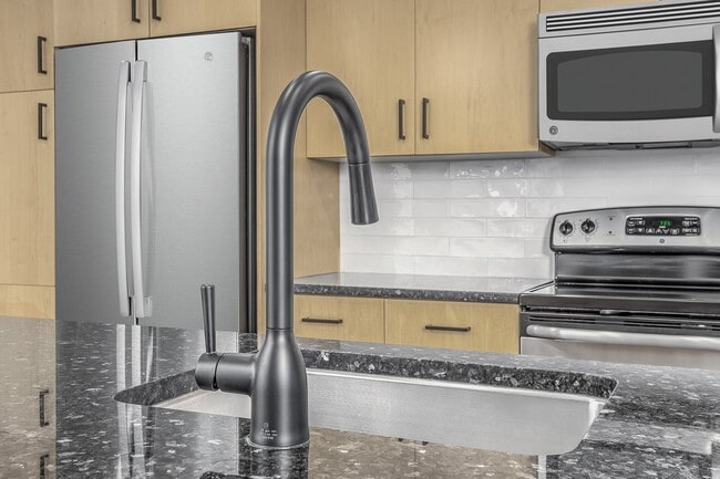 Beautifully renovated kitchens feature modern white subway tile backsplash and sleek matte black fixtures - Zoso Flats