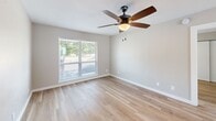 This two-story residence at 4425 Gilbert Ave in Dallas, Texas offers a well-designed layout spread across two floors. The main level hosts the open-concept kitchen and living area, while a white-railed staircase with light wood treads leads to the upper level. Throughout the home, light hardwood-style flooring and neutral warm-gray walls create a clean, cohesive aesthetic.

The kitchen is outfitted with white shaker cabinetry, stainless steel appliances including a range and over-the-range microwave, a white subway tile backsplash, open wooden shelving, and a bright white countertop that extends to a pass-through breakfast bar — a practical and stylish centerpiece.

The generously sized bedroom features a ceiling fan with light, a large window that brings in natural light and outdoor views, and ample closet storage. The four bathrooms reflect a consistent modern design, showcasing light blue-gray vanity cabinetry, white quartz countertops, undermount sinks with chrome fixtures, round black-framed mirrors, and crisp white subway tile tub surrounds.

Ceiling fans are present throughout the living areas and bedroom, enhancing comfort. The overall ambiance is clean, bright, and move-in ready, with thoughtful finishes that balance style and function across every room.