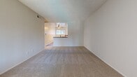 Located at 450 N Armando St in Anaheim, California, this single-floor, 2-bedroom, 1-bathroom home offers a practical and well-organized layout. The living area features warm wood-look vinyl flooring, a ceiling fan with light fixture, and an open sightline to the combined kitchen and dining space. The kitchen is appointed with white cabinetry, dark countertops, a gas range, built-in dishwasher, over-the-range microwave, and a raised breakfast bar, all complemented by vertical blinds on dual windows that invite natural light. The dining area flows seamlessly from the kitchen, creating a cohesive, open space ideal for everyday living. Both bedrooms are finished with plush carpeting and feature windows with vertical blinds. The primary bedroom includes a full-wall sliding closet for generous storage. Additional closets are distributed throughout the home, providing ample organization options. A hallway connects the bedrooms to the shared bathroom, which offers a double-sink vanity with grey stone countertops, white cabinetry, a large mirror, and wood-look flooring. The home also includes a dedicated utility room, pantry, and entrance area, rounding out a thoughtfully structured floor plan suited for comfortable everyday living.
